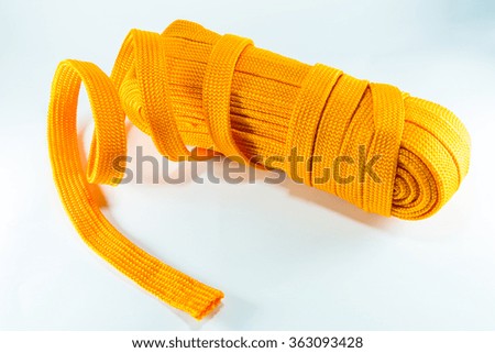 Orange rope rolls flat on white background.