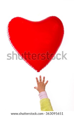 A child reaches for a hot air balloon in the shape of heart