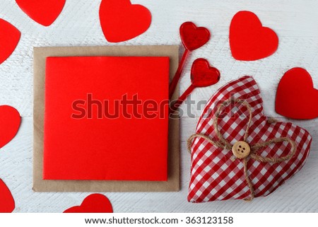 paper and cardboard heart with bow on wooden table