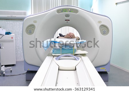 Patient being scanned and diagnosed on CT (computed tomography) scanner in hospital.
