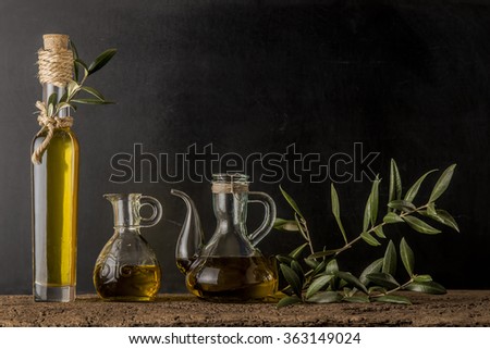 Bottle and glass jars of extra virgin olive oil on rustic background Royalty-Free Stock Photo #363149024