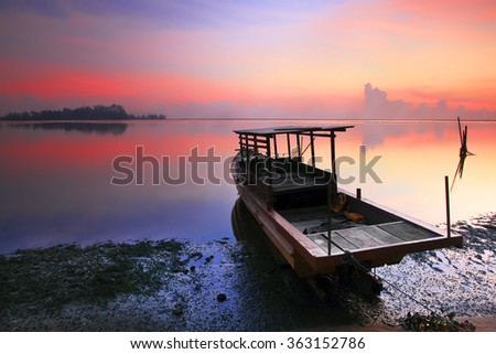 Beautiful sunrise over a wooden fisherman boat in Jubakar,Kelantan,Malaysia with beautiful sky and nice reflection.Popular place for photographer in malaysia.