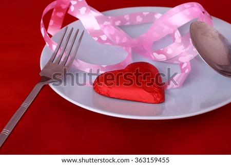 Valentines Day background with chocolates, red heart and ribbon