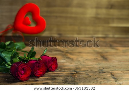 Rose and red heart on a wooden background