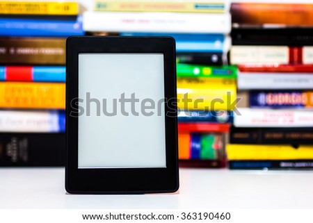 E-book reader on background of old books