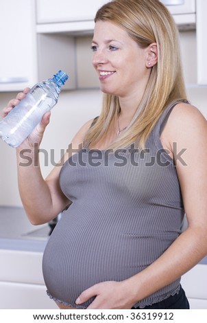 Young pregnant woman drinking water