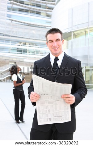 Handsome business man at the office reading a newspaper