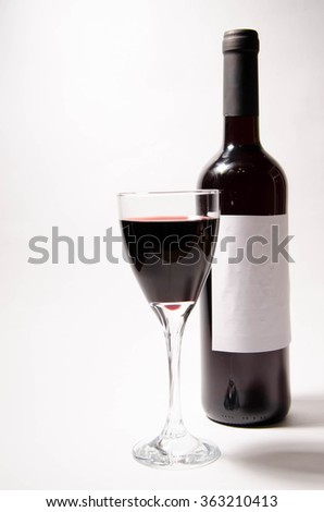 Red wine in glass and bottles, isolated, white background