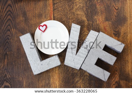 Metal love sign on wood background with plates