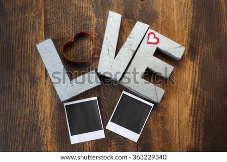 Metal love sign on wood background with pictures