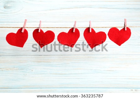 Love hearts hanging on rope on a blue wooden background Royalty-Free Stock Photo #363235787