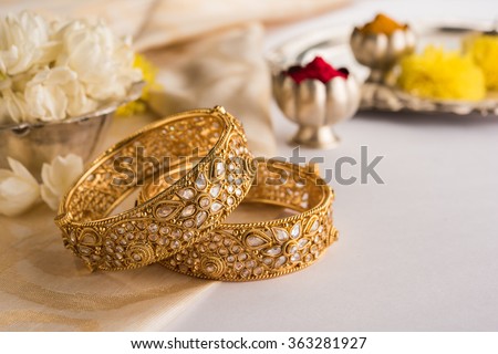 Indian traditional wedding jewellery, bangles with huldi kumkum and white flowers. selective focus Royalty-Free Stock Photo #363281927