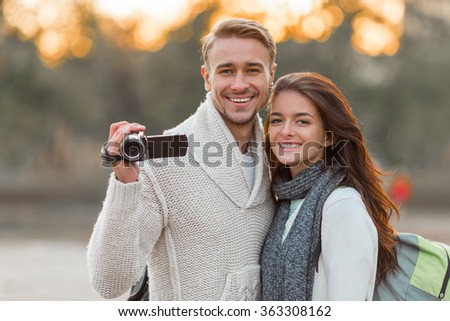 Young beautiful couple tourists use the camera during a walk in the city