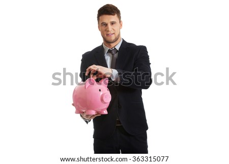 Businessman putting a coin to piggybank.