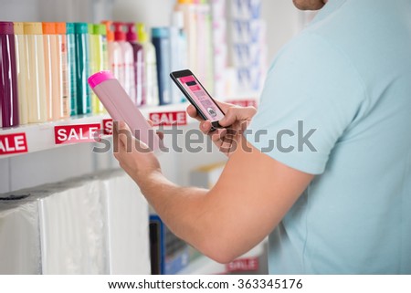 Cropped image of male customer photographing cosmetic product in supermarket
