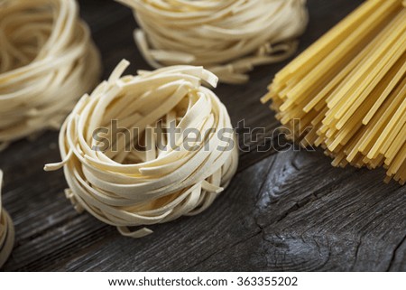 A set of raw pasta and addons on wooden table. Studio picture