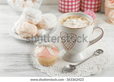 Mug of hot chocolate with marshmallows, on light wooden background