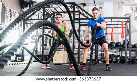 Men with battle rope in functional training fitness gym Royalty-Free Stock Photo #363373637