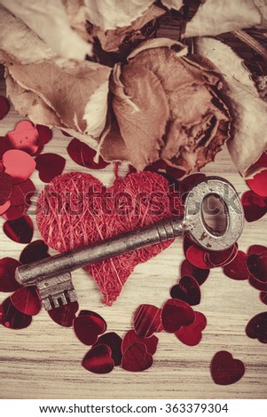 Key with the heart as a symbol of love, card with red heart on wooden background/valentines day background, retro color tone