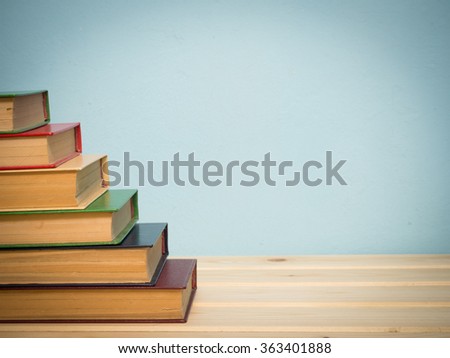 Books on a wooden shelf on a blue background