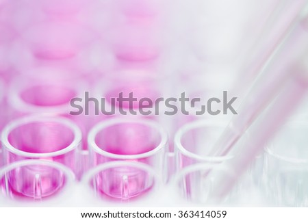 Pipetting pink liquid into multi-well plate Royalty-Free Stock Photo #363414059