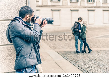 Reporter photographing a famous vip couple on a romantic date - Detective inquiring in a couple betrayal Royalty-Free Stock Photo #363422975