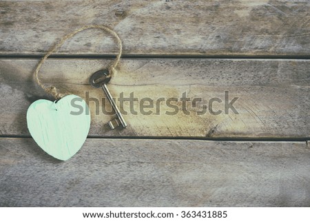 top view of key and heart on wooden background
