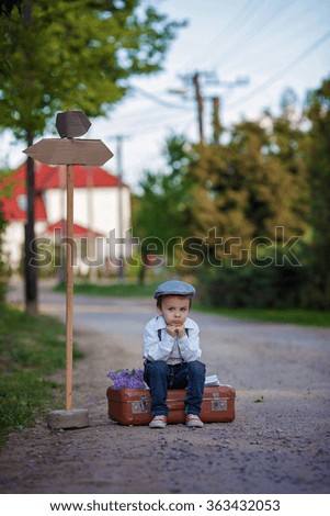 Little boy with suitcase and map, traveling