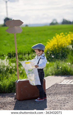 Little boy with suitcase and map, traveling