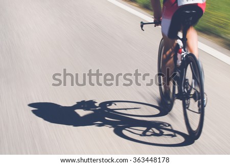 Speedy shadow - A cyclist at top speed on the triathlon race. Royalty-Free Stock Photo #363448178