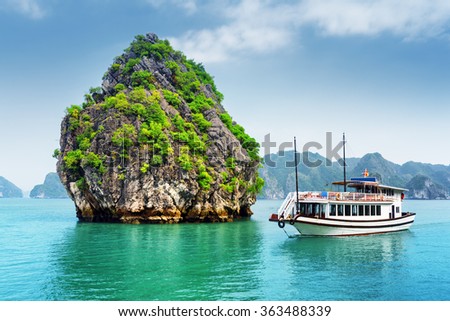 Beautiful view of karst isle and tourist boat in the Ha Long Bay (Descending Dragon Bay) at the Gulf of Tonkin of the South China Sea, Vietnam. The Halong Bay is a popular tourist destination of Asia Royalty-Free Stock Photo #363488339