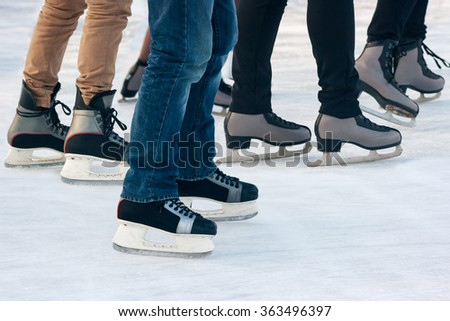 legs of people skating on winter day closeup