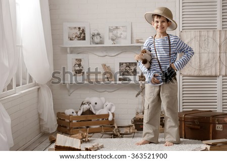 Little boy in the image of sailor playing in her room 
