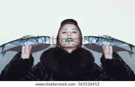 Girl in a fur coat with fish