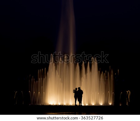 Romance abstract background, Couples take a photograph with fountain at night.