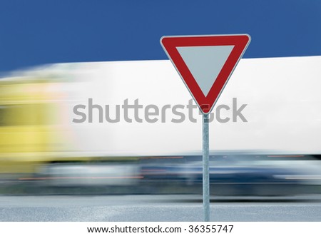 Give way yield road traffic sign and truck in the background