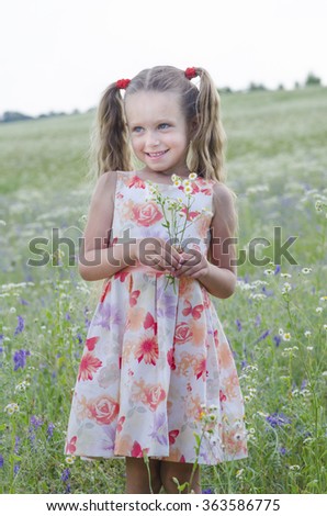 Beautiful girl on field of flowers on summer time