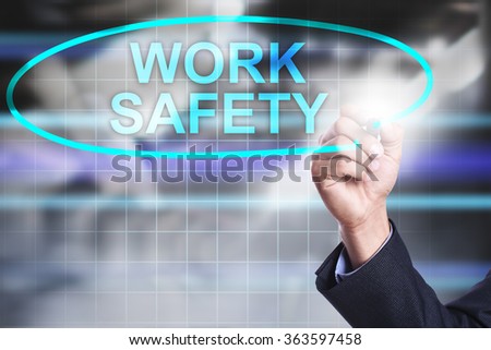 Businessman drawing on virtual screen text "Work safety". Business concept. Internet concept.