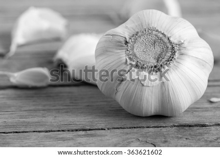 Black and white garlic on a wooden table.
