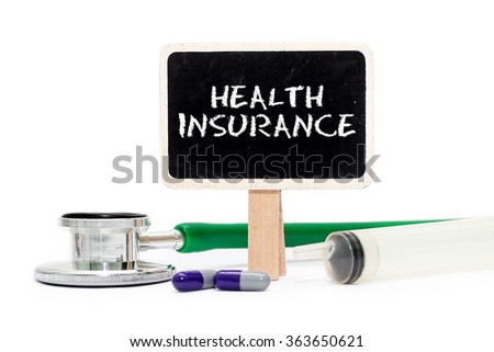 HEALTH INSURANCE concept with text on chalkboard with stethoscope, syringe and pills
