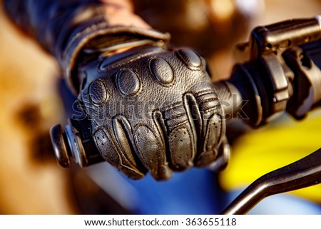 Human hand in a Motorcycle Racing Gloves holds a motorcycle throttle control. Hand protection from falls and accidents.