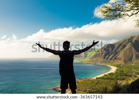 Male hiker with arms out stretched taking in the view. 
