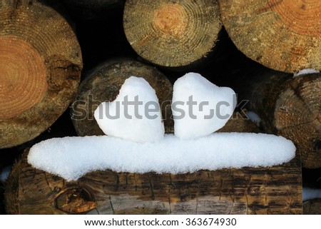 two hearts from snow on wood billets,