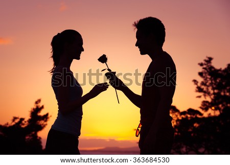 Male giving girl a rose. 