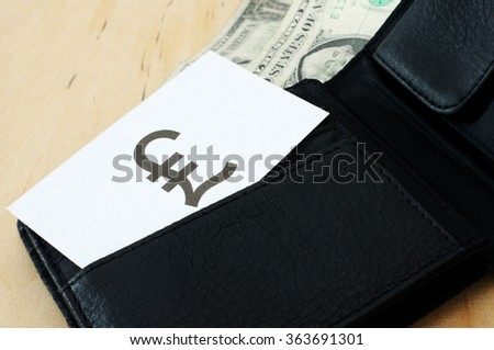 Business card with the sign BRITISH POUND in wallet with dollars

