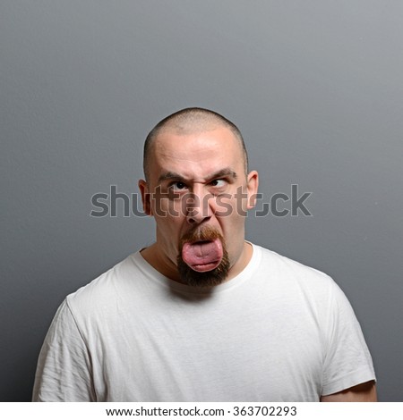 Portrait of a man making funny face against gray background
