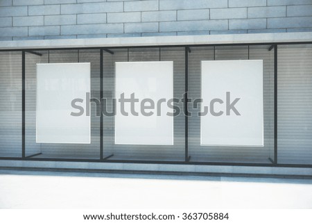 Blank white posters in glassy showcase on the street, mock up