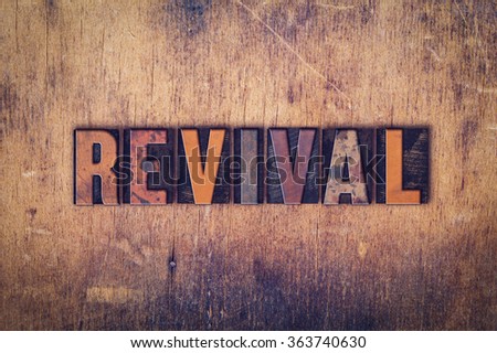 The word "Revival" written in dirty vintage letterpress type on a aged wooden background. Royalty-Free Stock Photo #363740630