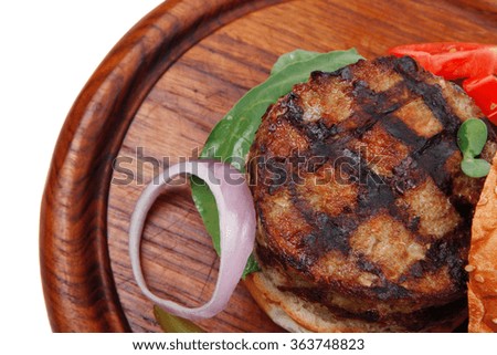 extra thick hot beef meat hamburger dinner on wooden plate with tomatoes and salad isolated on white background