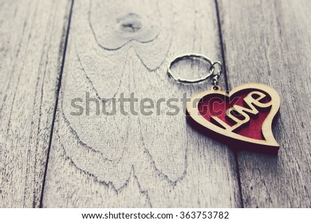 Vintage,Key of Love in hand,Heart Keychain on wood table
